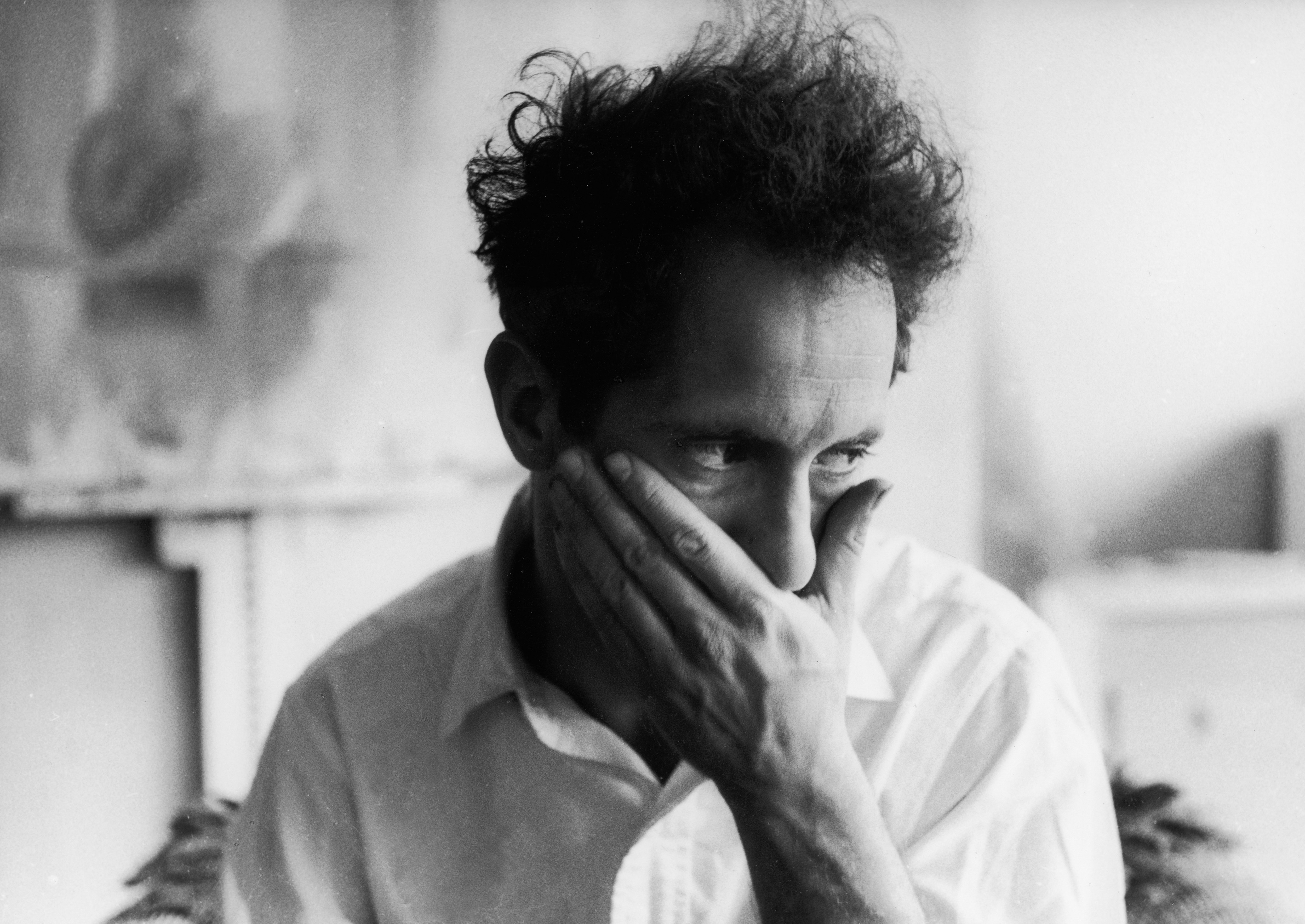 Swiss-born American photographer Robert Frank puts his hand over his mouth in this portrait, 1958. (Photo by John Cohen/Getty Images)